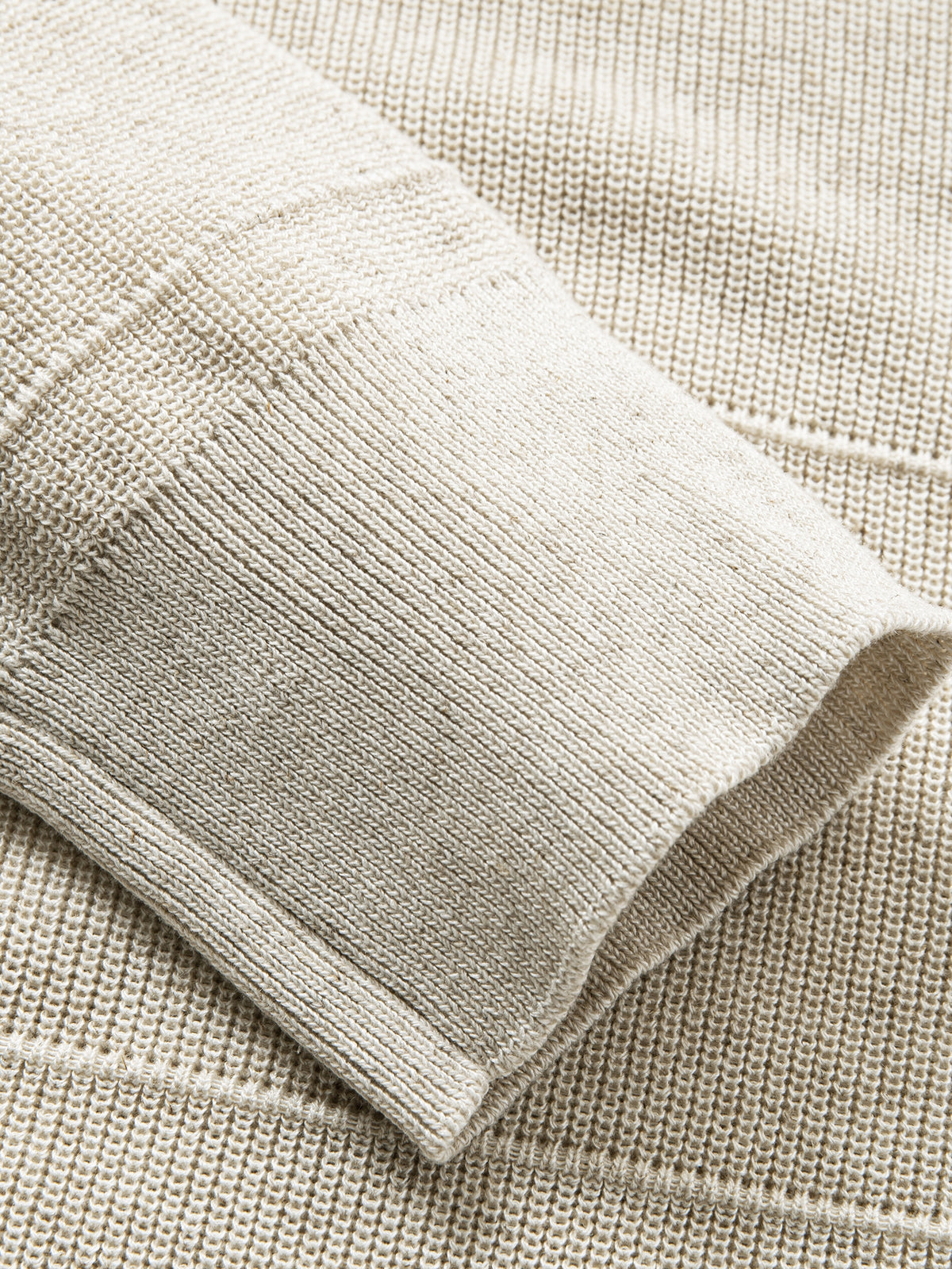 Detailed view of long sleeve ribbed cuffs on oatmeal textured polo knit cardigan