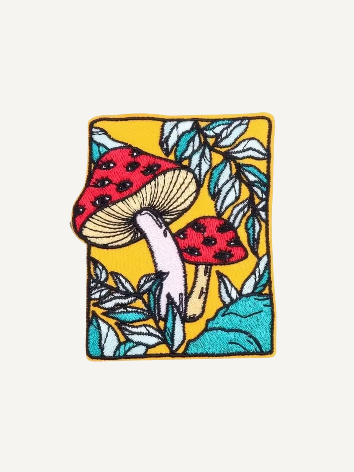 Embroidered red fly agaric mushroom graphic detail on OROMEN T-shirt