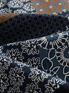 Macro texture close-up of 100% cotton twill fabric featuring Japanese Asanoha star and geometric patchwork print