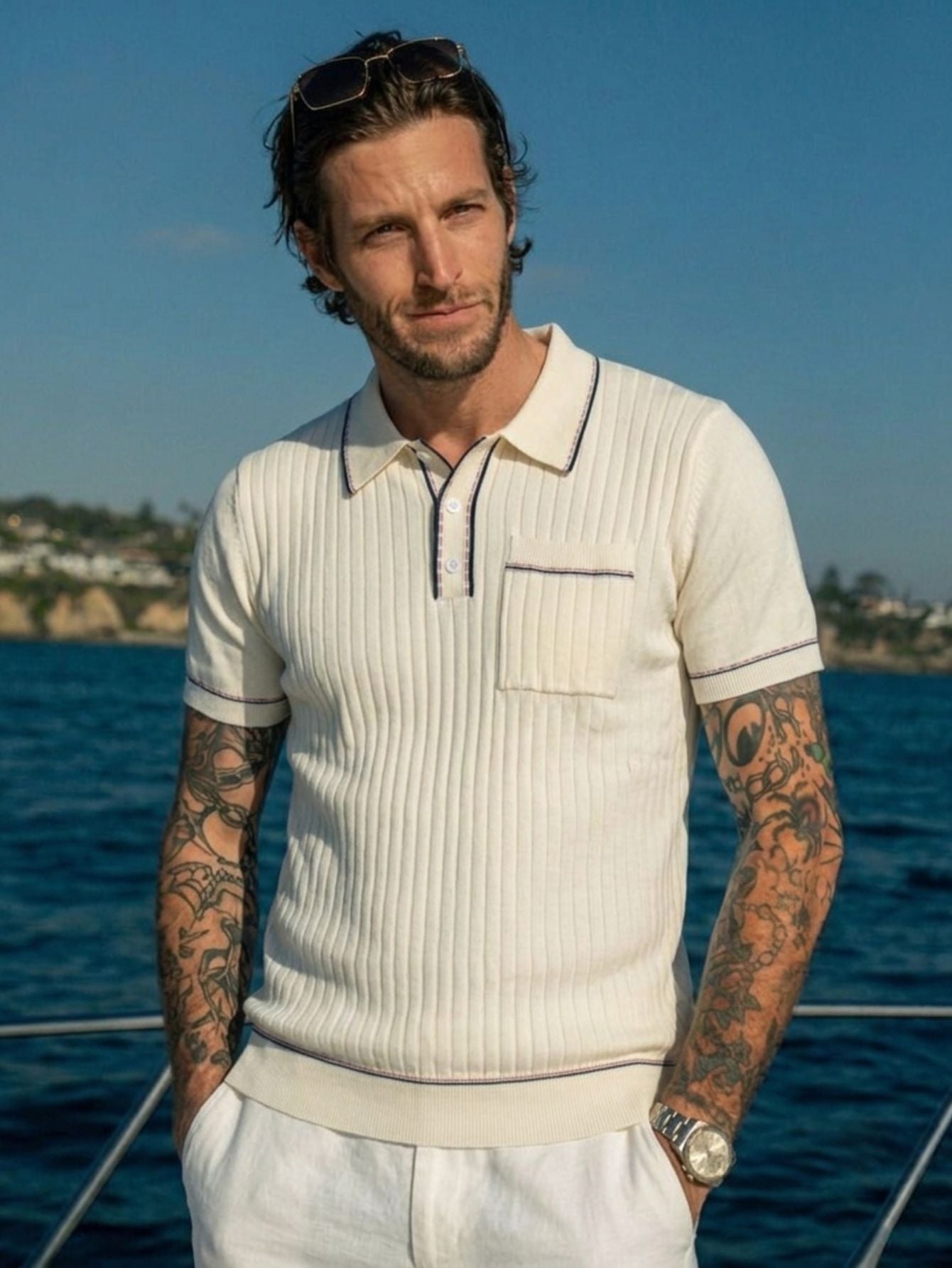 Male model wearing OROMEN cream ribbed knit polo shirt, front view,
styled with contrast tipping detail, quiet luxury sportswear aesthetic