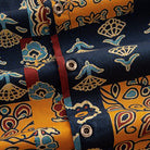 OROMEN Ajrakh Mosaic shirt branded coconut button close-up against folk bird, floral and paisley patchwork panels with burgundy placket