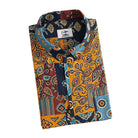 OROMEN Ajrakh Mosaic shirt folded display showing branded label, coconut buttons and multi-color Ajrakh patchwork print in navy, amber, slate blue and burgundy
