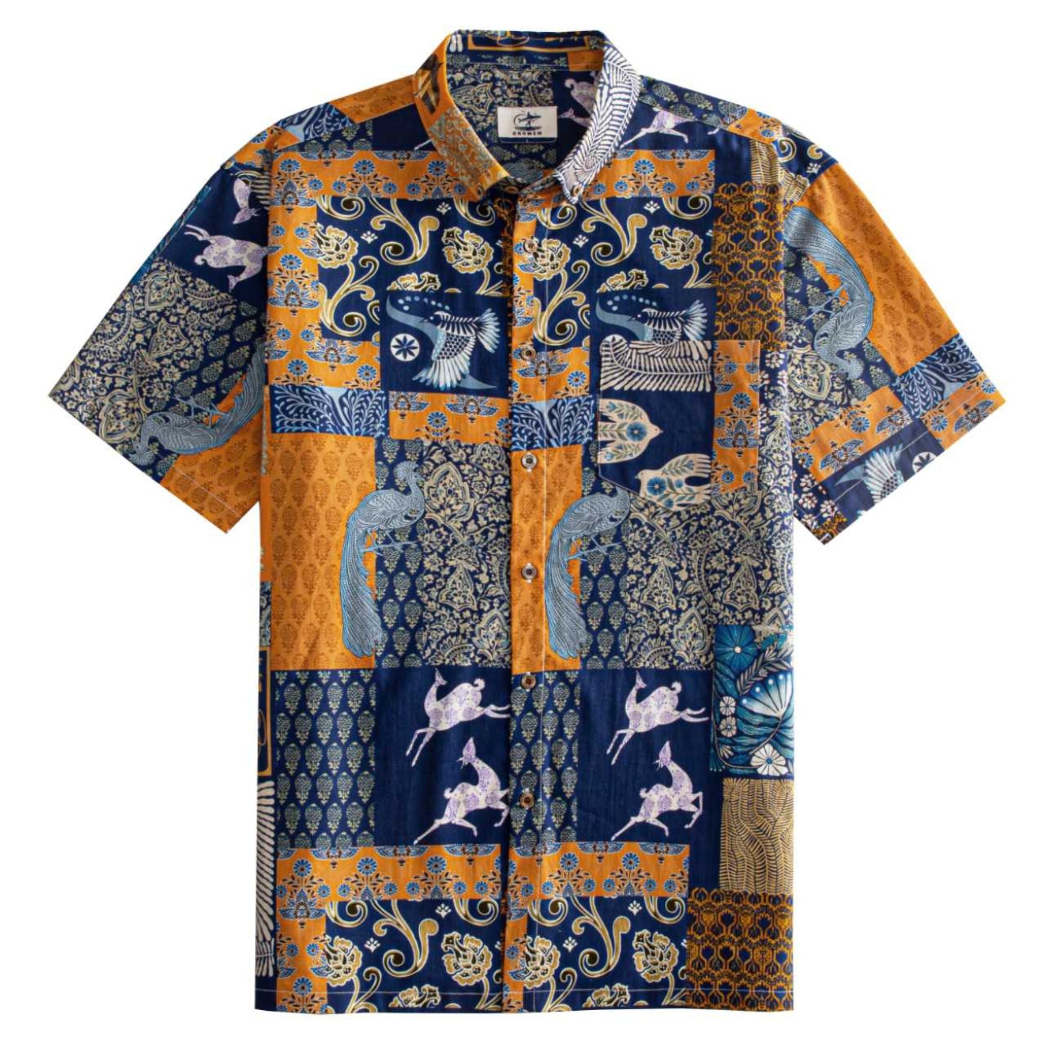 OROMEN Aviary Patchwork Hawaiian shirt front flat lay showing full patchwork block layout with peacocks, folk birds and botanical motifs in navy blue and amber orange