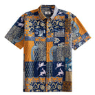 OROMEN Aviary Patchwork Hawaiian shirt front flat lay showing full patchwork block layout with peacocks, folk birds and botanical motifs in navy blue and amber orange