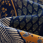 OROMEN Aviary Patchwork shirt fabric close-up showing fern leaf and circular tree motif patchwork panels on navy blue 100% premium cotton