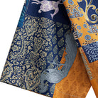 OROMEN Aviary Patchwork shirt sleeve detail showing folk bird and Persian floral patchwork motifs on navy blue and amber orange cotton