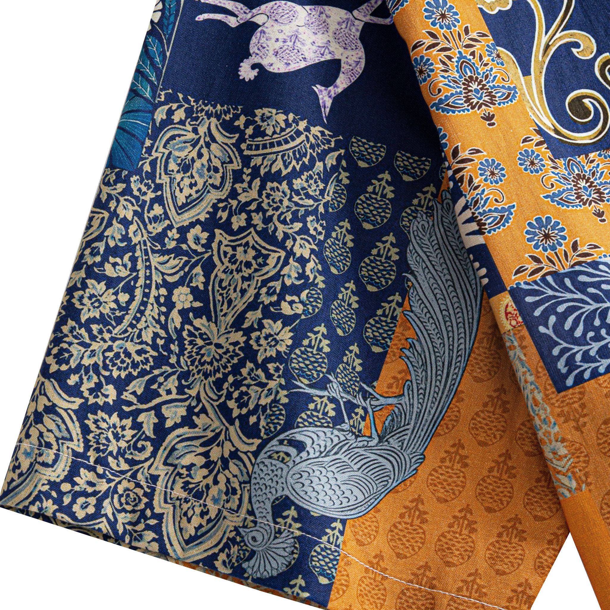 OROMEN Aviary Patchwork shirt sleeve detail showing folk bird and Persian floral patchwork motifs on navy blue and amber orange cotton