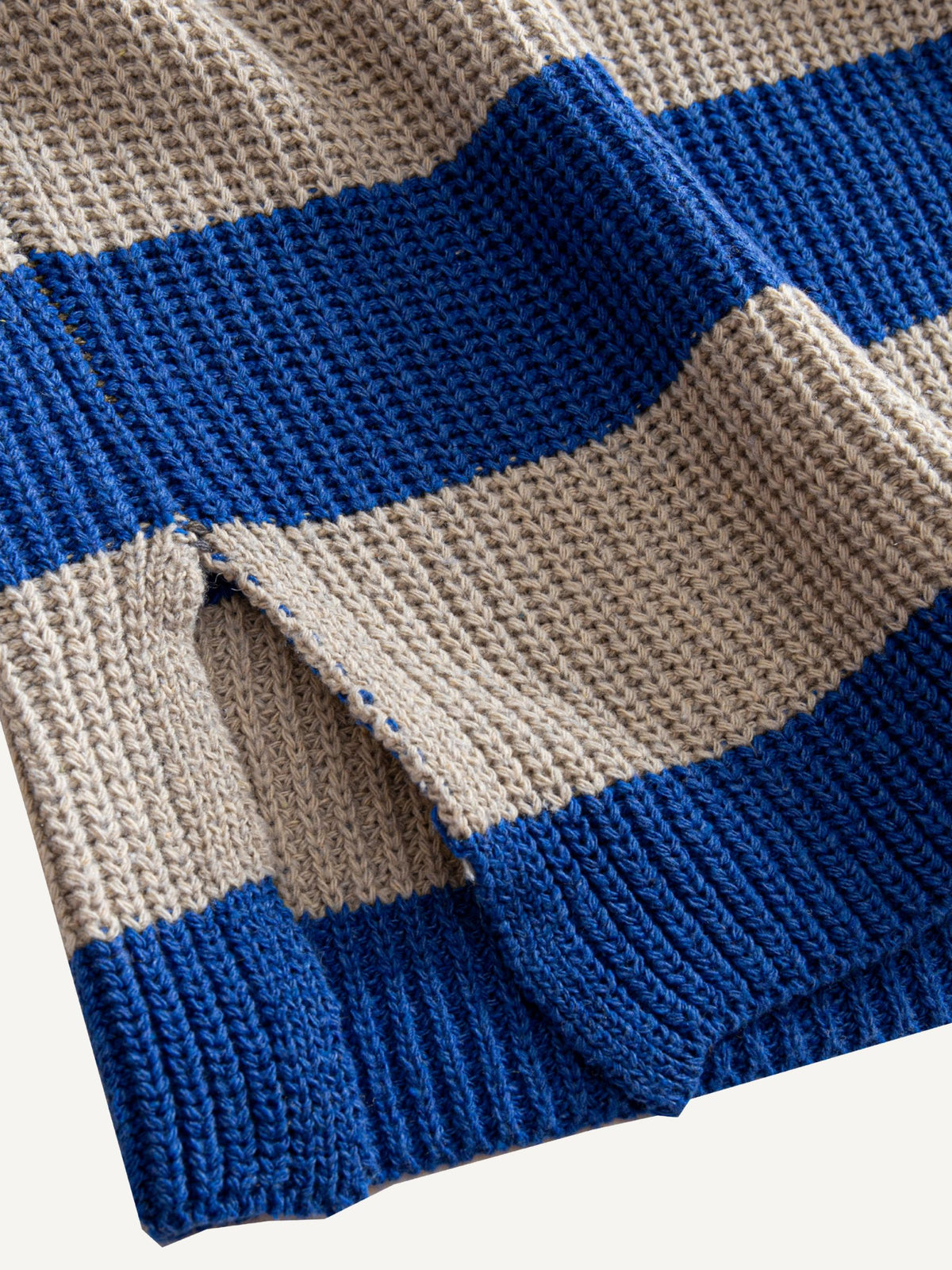 OROMEN Color-Block Striped V-Neck Sweater side slit detail highlighting relaxed hem vent