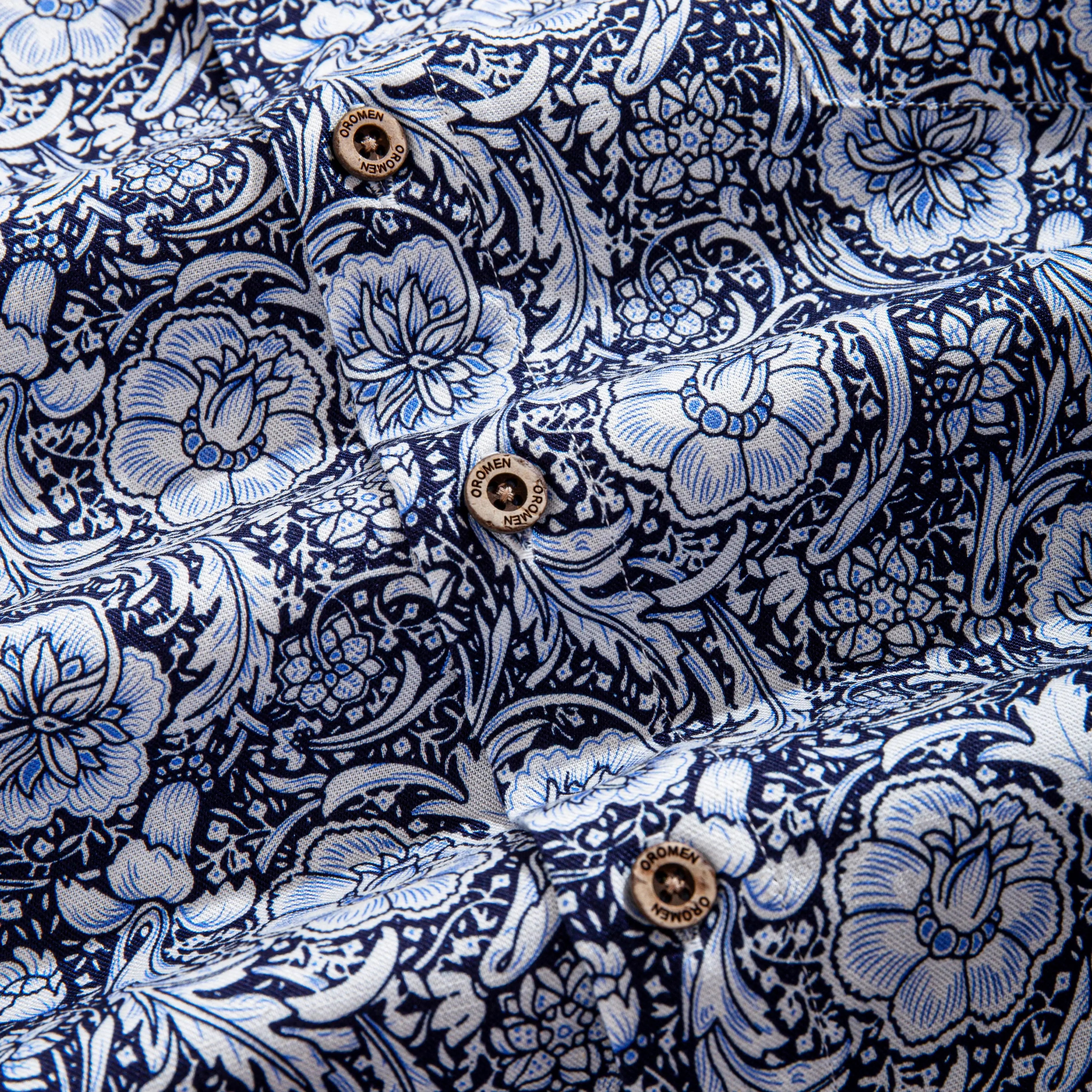 OROMEN Finesse Hall Hawaiian Shirt — OROMEN branded coconut buttons close-up on Arts & Crafts floral print