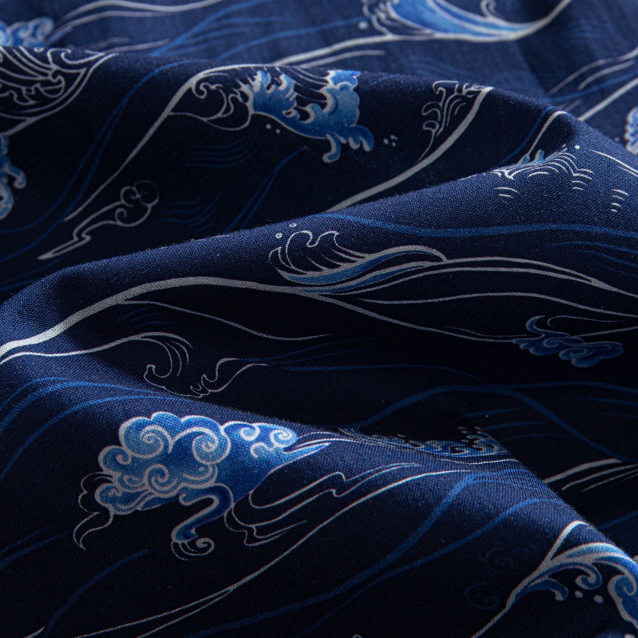 OROMEN Hokusai Kairin shirt fabric close-up, white wave lines and blue cloud motifs on deep navy cotton