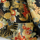 OROMEN Kiku & Fan shirt – close-up of hand-painted fabric showing gold fan ribs, white chrysanthemum blooms, red berries and blue foliage on black cotton