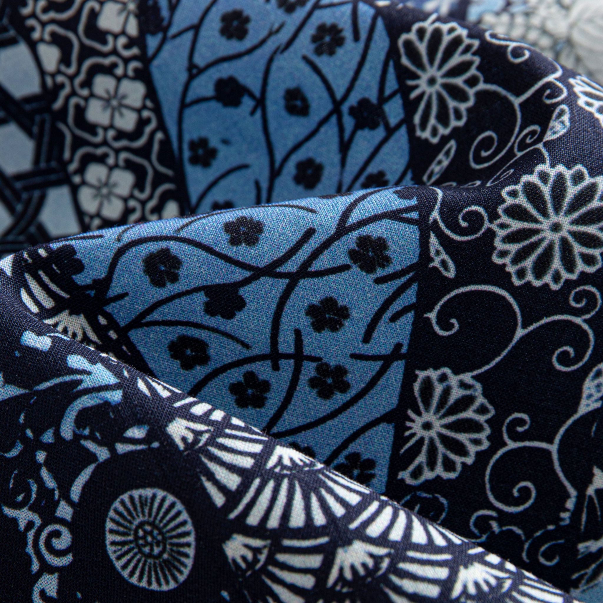 OROMEN Komon Patchwork shirt fabric close-up, karakusa vine, fan and floral patchwork in navy and sky blue cotton