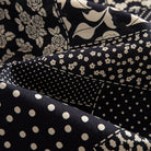 OROMEN Noir Patchwork shirt fabric close-up showing lace medallion, leopard spot, polka dot and diamond grid patchwork panels in black and off-white 100% premium cotton