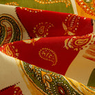 OROMEN Rajasthan Paisley shirt fabric close-up showing crimson block with intricate paisley swirl motifs and olive green border on 100% premium cotton