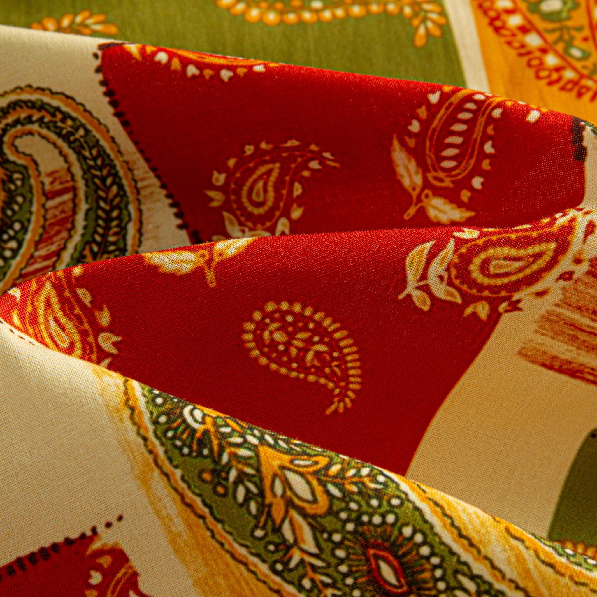 OROMEN Rajasthan Paisley shirt fabric close-up showing crimson block with intricate paisley swirl motifs and olive green border on 100% premium cotton