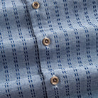 OROMEN Sashiko Chambray shirt branded coconut button close-up, navy Sashiko stitch on chambray blue