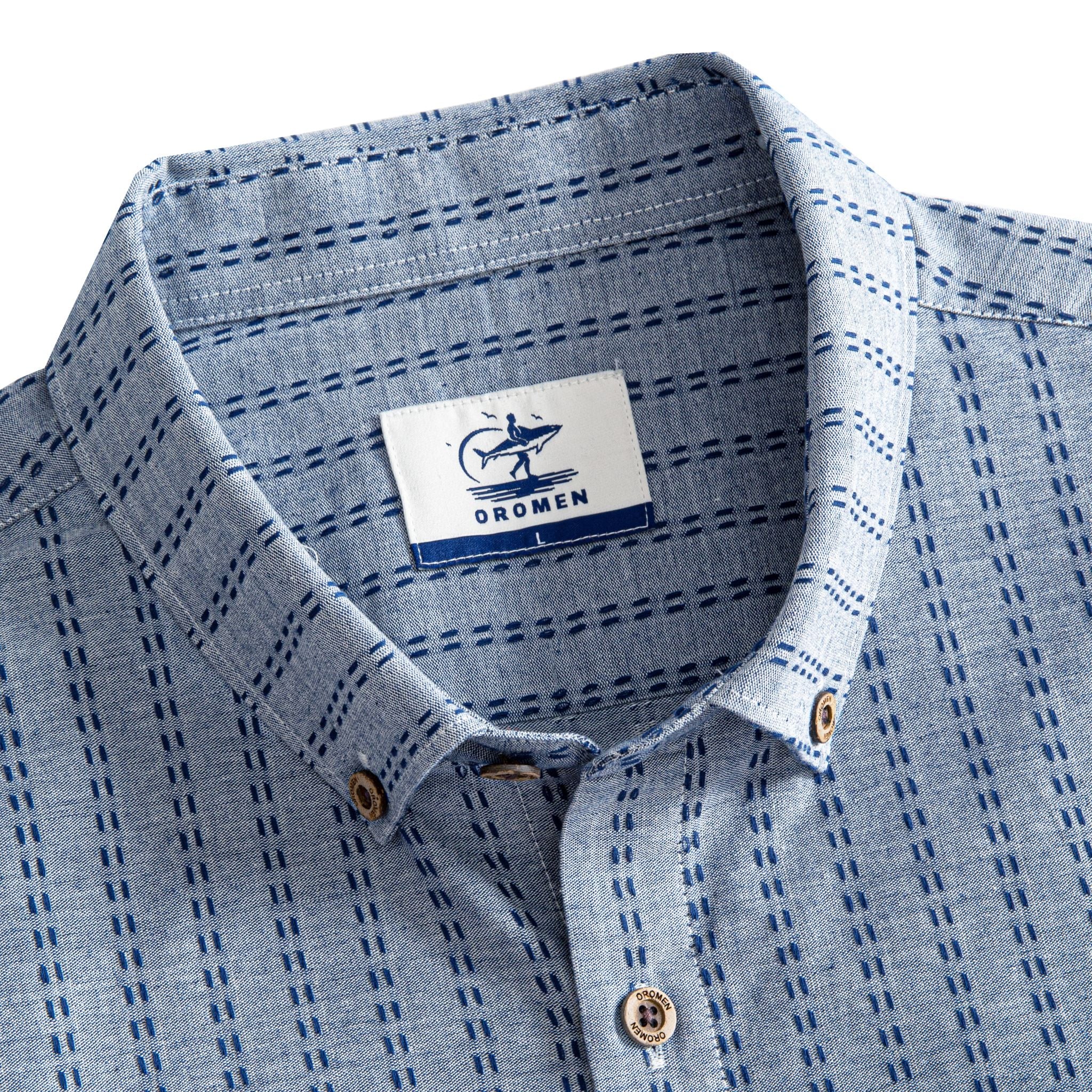 OROMEN Sashiko Chambray shirt button-down collar and branded label detail, navy Sashiko stitch on chambray blue