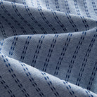 OROMEN Sashiko Chambray shirt fabric close-up, navy Sashiko dash texture on washed chambray blue cotton
