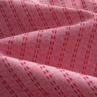 OROMEN Sashiko Stripe shirt fabric close-up, crimson running stitch stripe texture on rose pink cotton