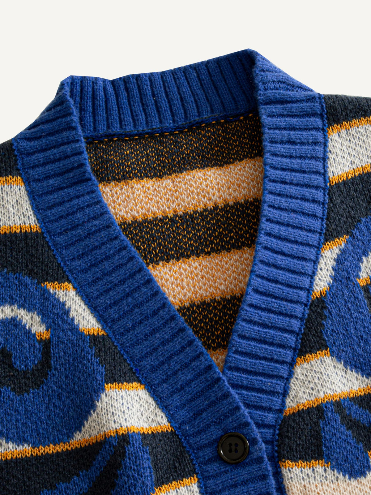 OROMEN Striped Swirl Jacquard Knit Cardigan collar detail showing cobalt blue ribbed V-neckline