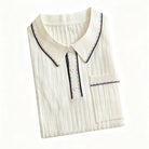 OROMEN cream ribbed knit polo shirt neatly folded, showcasing fine
vertical rib texture, contrast tipping details and off-white colorway