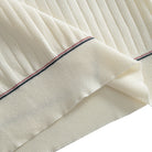 Ribbed hem close-up on OROMEN cream polo shirt, contrast stripe
finishing, fine vertical rib texture, clean structured edge
