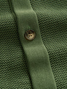 Shell-textured button closure detail of OROMEN Marcel Striped Knit Polo