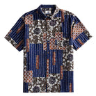 Silk Road Patchwork Hawaiian shirt front flat lay showing full patchwork block layout with indigo ikat stripes, dark brown florals and ethnic geometric panels