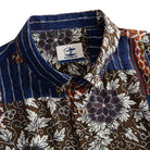 Silk Road Patchwork shirt collar detail showing OROMEN branded label, coconut buttons and patchwork panels of dark brown floral and indigo ikat stripe