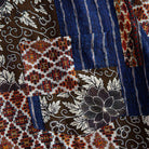 Silk Road Patchwork shirt fabric close-up showing dark brown floral, indigo ikat stripe and Persian carpet medallion patchwork panels