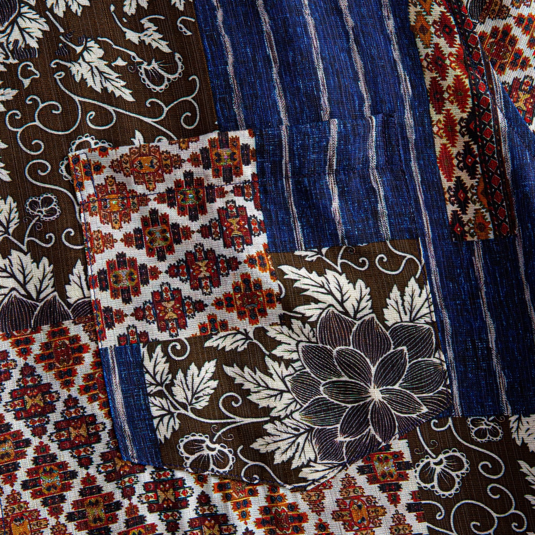 Silk Road Patchwork shirt fabric close-up showing dark brown floral, indigo ikat stripe and Persian carpet medallion patchwork panels