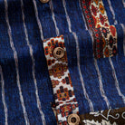 Silk Road Patchwork shirt placket close-up with OROMEN branded coconut buttons on ethnic geometric trim against indigo ikat stripe body
