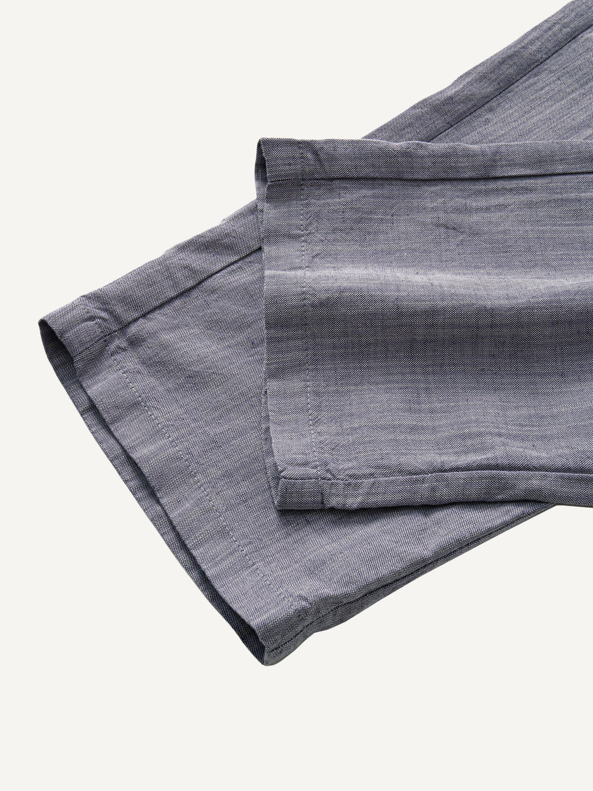 Tapered leg and pre-rolled cuff detail of OROMEN Pleated Relaxed Fit Linen Trousers