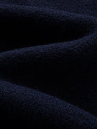 Texture detail of soft stretch-knit polyester blend fabric on navy contrast collar polo sweater
