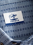 Woven neck brand label and inner collar detail of OROMEN Sashiko Chambray Cotton Shirt